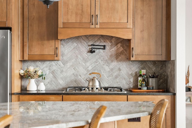 kitchen with dark stone counters, appliances with stainless steel finishes, and decorative backsplash