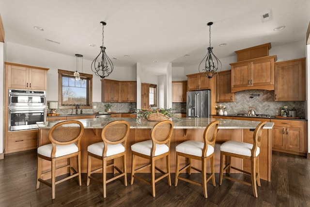 kitchen featuring stainless steel appliances, recessed lighting, backsplash, and a spacious island