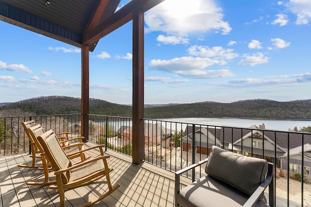 wooden terrace featuring a view of trees and a water and mountain view