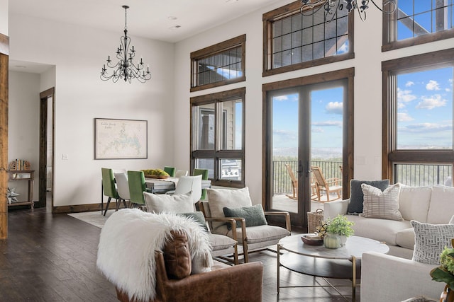living room featuring baseboards, plenty of natural light, a notable chandelier, and hardwood / wood-style flooring