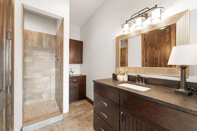 full bathroom featuring a walk in shower, stone finish floor, and vanity