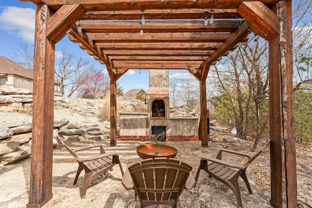 view of patio featuring an outdoor stone fireplace and a pergola