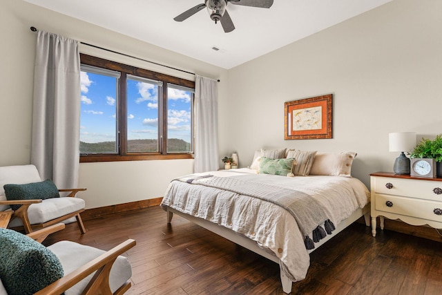 bedroom with dark wood-type flooring, baseboards, a ceiling fan, and visible vents