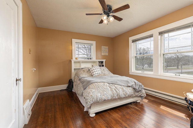 218 Lillian Pl, Bolivar, MO 65613 - bedroom featuring a ceiling fan, baseboards, a baseboard heating unit, and wood finished floors