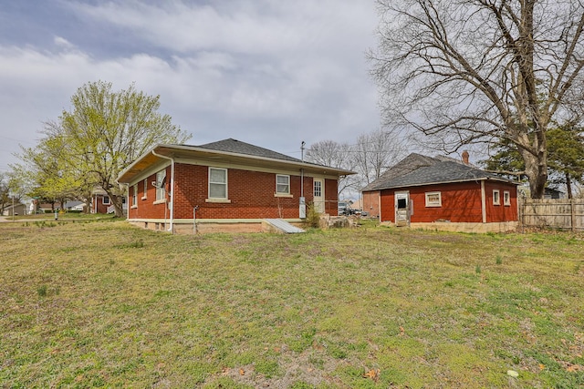 218 Lillian Pl, Bolivar, MO 65613 - back of property featuring a lawn, brick siding, and fence