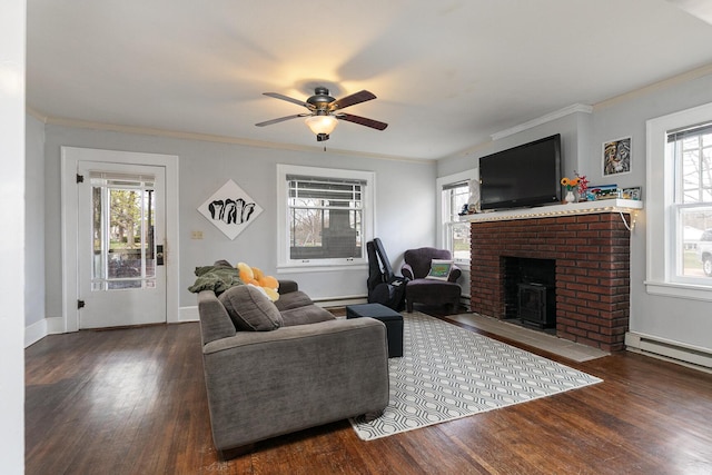 218 Lillian Pl, Bolivar, MO 65613 - living area with baseboard heating, a fireplace, wood finished floors, and a ceiling fan