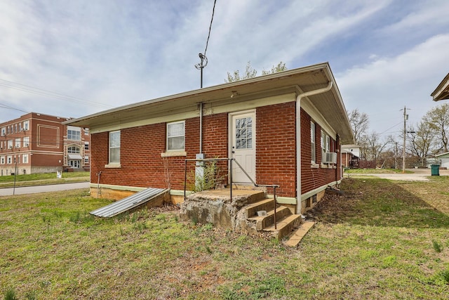 218 Lillian Pl, Bolivar, MO 65613 - view of front of home featuring cooling unit, brick siding, and a front lawn