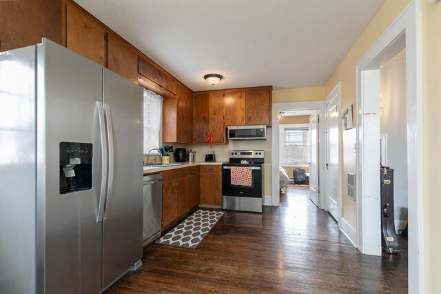 218 Lillian Pl, Bolivar, MO 65613 - kitchen featuring light countertops, a sink, brown cabinetry, stainless steel appliances, and dark wood-type flooring