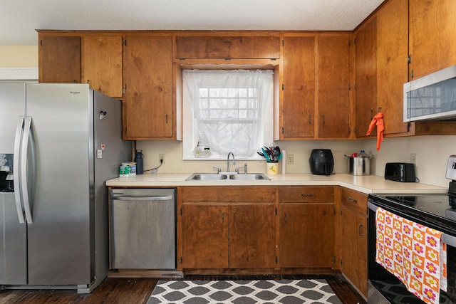 218 Lillian Pl, Bolivar, MO 65613 - kitchen featuring a sink, light countertops, appliances with stainless steel finishes, and brown cabinetry