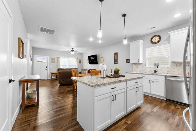 201-217 Watersound Way, Hollister, MO 65672 - kitchen with backsplash, dark wood-style flooring, visible vents, and stainless steel dishwasher