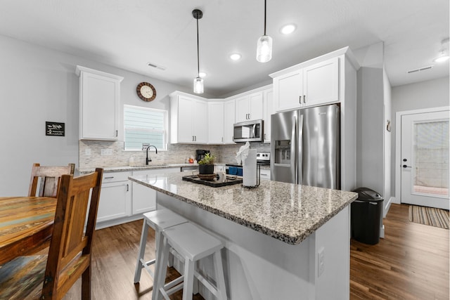 201-217 Watersound Way, Hollister, MO 65672 - kitchen with visible vents, stainless steel appliances, a kitchen island, a sink, and dark wood-style floors
