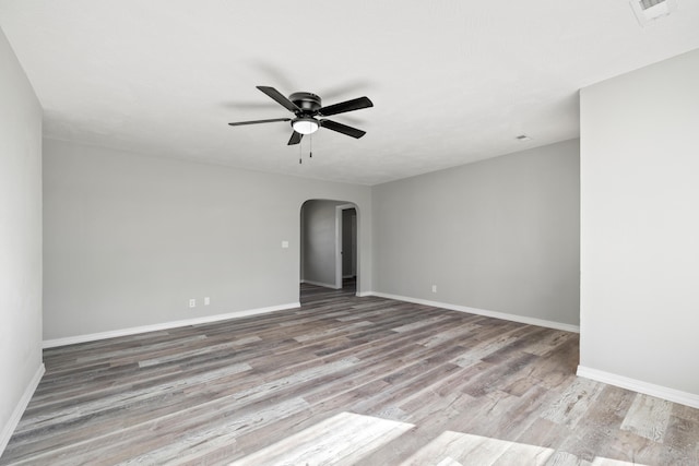 200 N Madison Ave, Mansfield, MO 65704 - unfurnished room featuring baseboards, arched walkways, visible vents, ceiling fan, and wood finished floors
