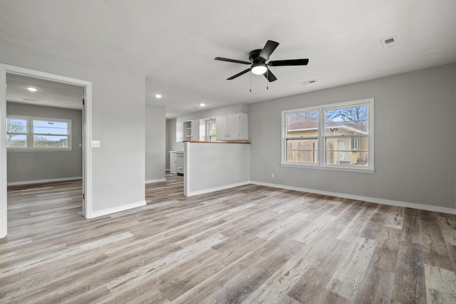 200 N Madison Ave, Mansfield, MO 65704 - unfurnished living room featuring baseboards, ceiling fan, visible vents, and light wood finished floors