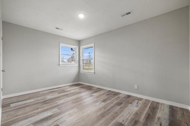 200 N Madison Ave, Mansfield, MO 65704 - empty room featuring baseboards, visible vents, wood finished floors, and a textured ceiling