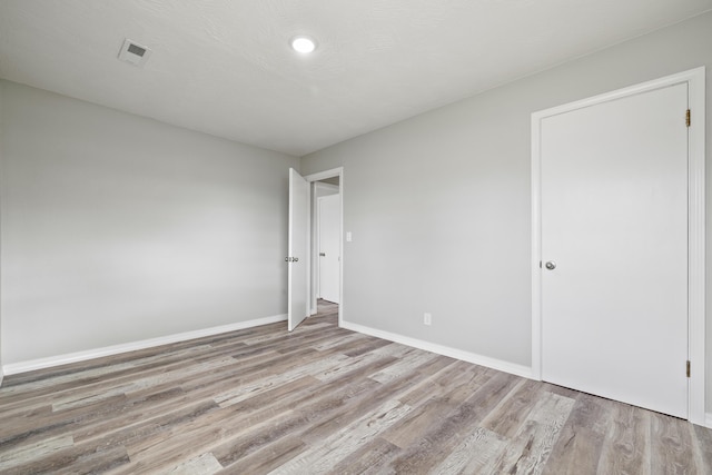 200 N Madison Ave, Mansfield, MO 65704 - unfurnished bedroom featuring baseboards, visible vents, and light wood-type flooring
