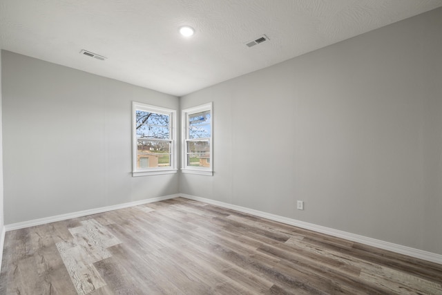 200 N Madison Ave, Mansfield, MO 65704 - empty room featuring baseboards, visible vents, a textured ceiling, and wood finished floors