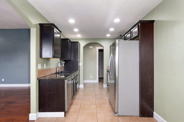 1471 Woodland Rd, Marshfield, MO 65706 - kitchen featuring appliances with stainless steel finishes, arched walkways, recessed lighting, dark brown cabinetry, and light tile patterned floors