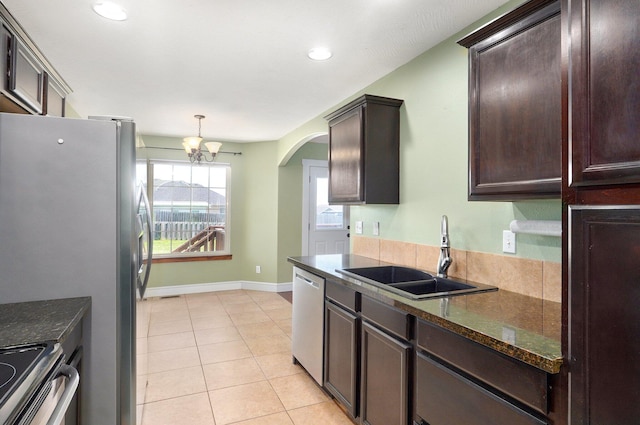 1471 Woodland Rd, Marshfield, MO 65706 - kitchen featuring appliances with stainless steel finishes, dark brown cabinetry, arched walkways, a chandelier, and dark stone counters