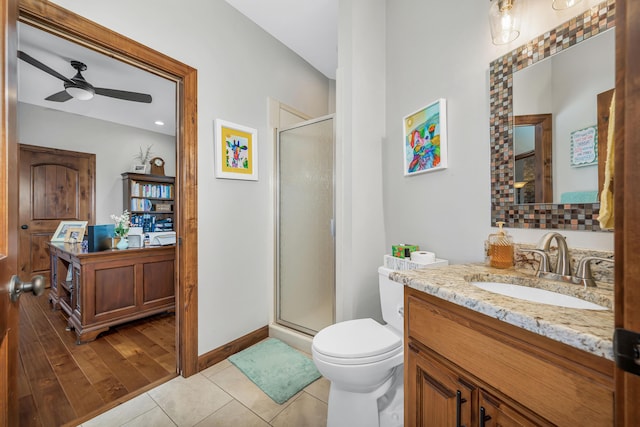 full bath with a stall shower, toilet, vanity, a ceiling fan, and tile patterned flooring