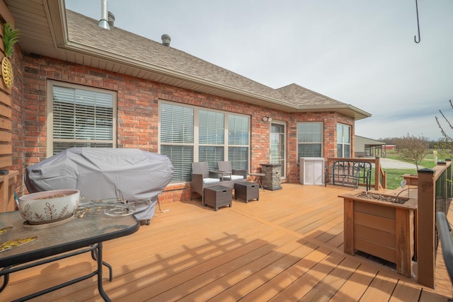 deck featuring a grill and an outdoor fire pit