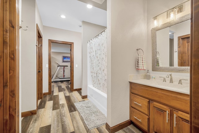 full bathroom with vanity, baseboards, and wood finished floors