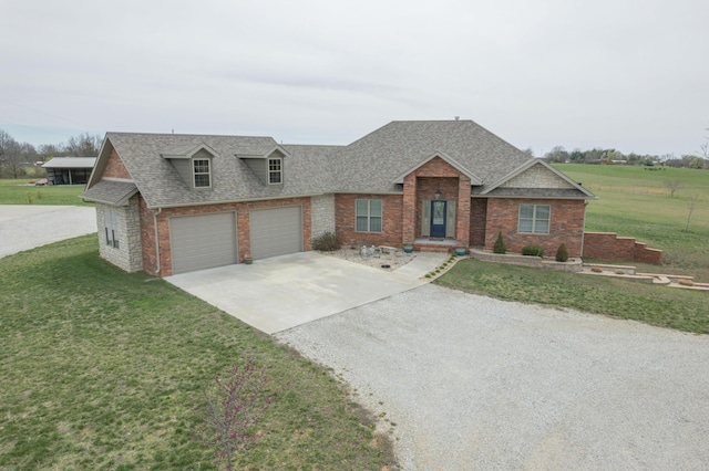view of front of home featuring a shingled roof, a front lawn, concrete driveway, and brick siding