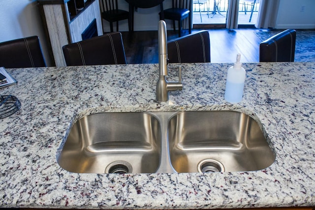 interior details featuring light stone countertops and a sink