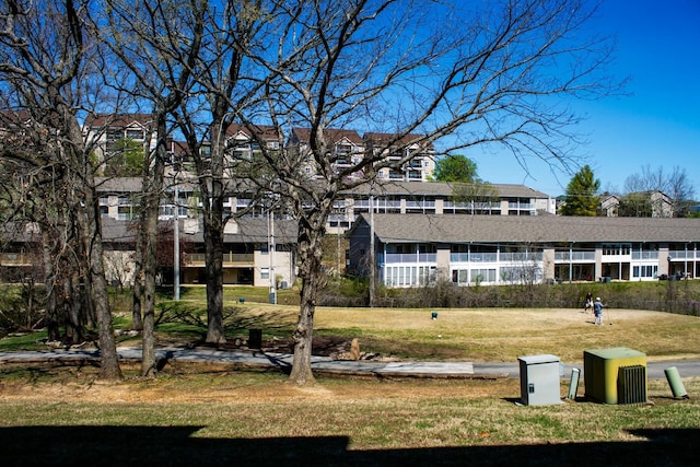 exterior space featuring roof with shingles, a yard, and a residential view