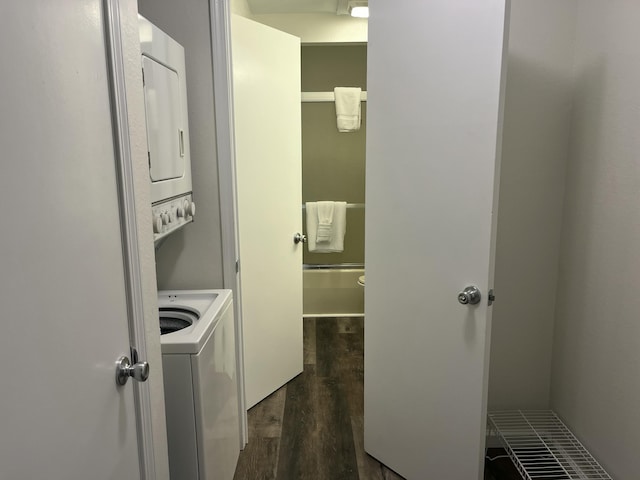 clothes washing area with stacked washer and dryer, laundry area, and dark wood finished floors