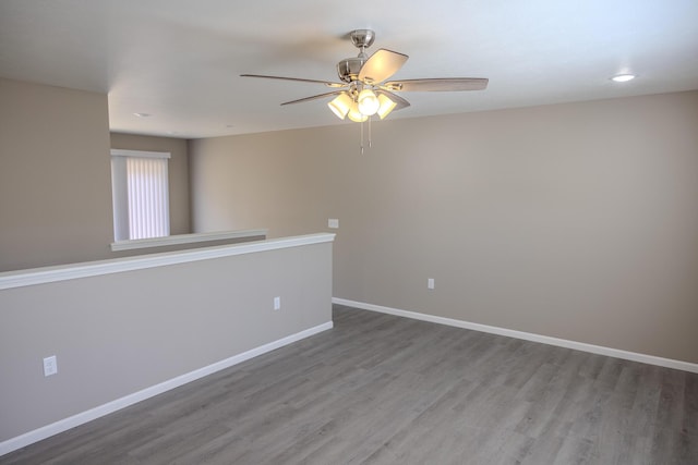 unfurnished room featuring baseboards, ceiling fan, and wood finished floors