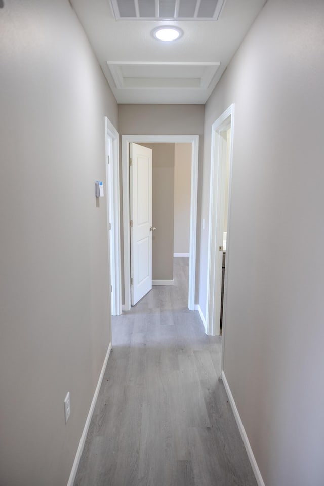 corridor with wood finished floors, baseboards, and visible vents