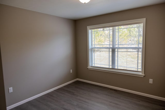 empty room with baseboards and dark wood finished floors