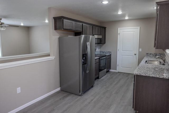 kitchen with dark brown cabinetry, a sink, appliances with stainless steel finishes, baseboards, and ceiling fan