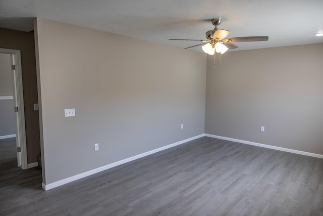 unfurnished room with dark wood-style floors, baseboards, and ceiling fan