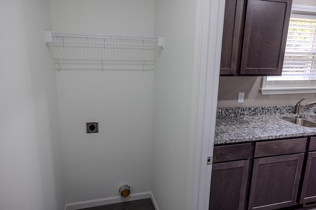 laundry area featuring baseboards, cabinet space, a sink, and electric dryer hookup