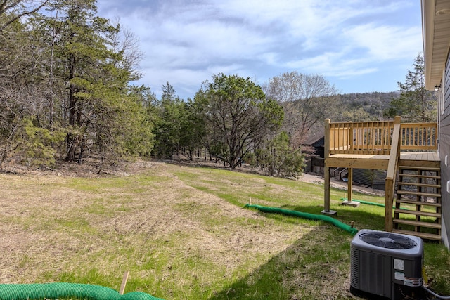 view of yard featuring cooling unit, a wooden deck, and stairway