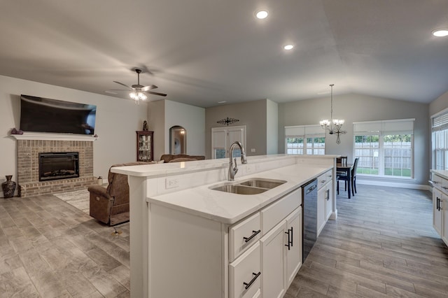 1859 Boyer Pl, Webb City, MO 64870 - kitchen featuring a brick fireplace, a kitchen island with sink, a sink, dishwashing machine, and light wood-type flooring