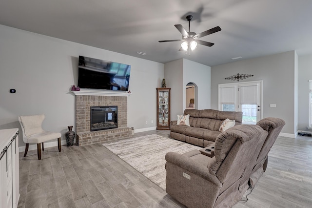 1859 Boyer Pl, Webb City, MO 64870 - living area with arched walkways, light wood-style floors, a fireplace, and ceiling fan