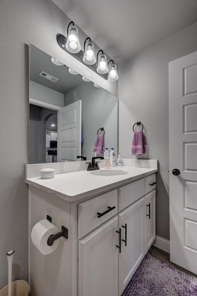 1859 Boyer Pl, Webb City, MO 64870 - bathroom with vanity, a textured wall, baseboards, and visible vents