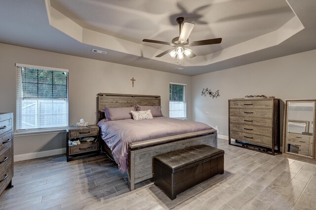 1859 Boyer Pl, Webb City, MO 64870 - bedroom featuring baseboards, visible vents, a tray ceiling, and wood tiled floor