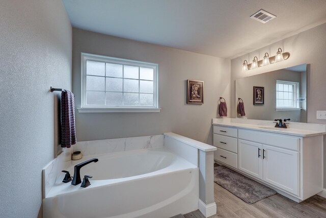 1859 Boyer Pl, Webb City, MO 64870 - bathroom with visible vents, wood finished floors, vanity, and a bath