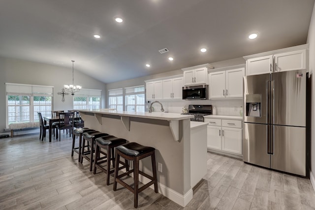 1859 Boyer Pl, Webb City, MO 64870 - kitchen featuring light countertops, a breakfast bar area, vaulted ceiling, light wood-type flooring, and appliances with stainless steel finishes