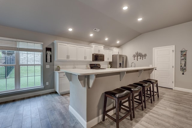 1859 Boyer Pl, Webb City, MO 64870 - kitchen with light countertops, light wood-type flooring, stainless steel appliances, a kitchen island with sink, and white cabinets