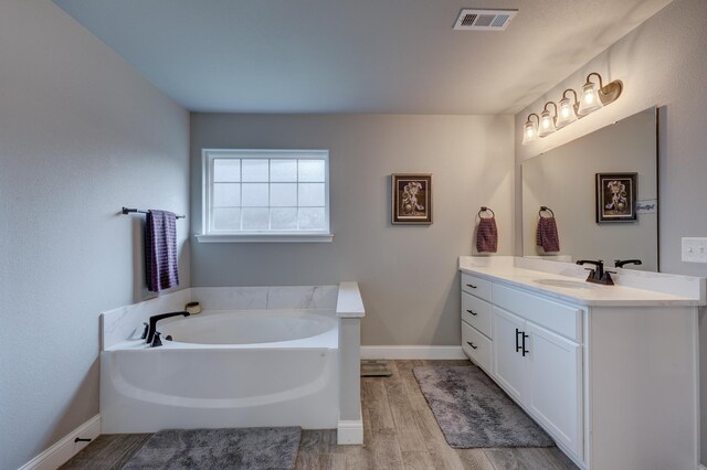 1859 Boyer Pl, Webb City, MO 64870 - full bathroom with vanity, wood finished floors, a bath, baseboards, and visible vents