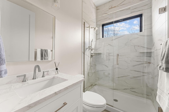 full bathroom featuring a marble finish shower, toilet, and vanity