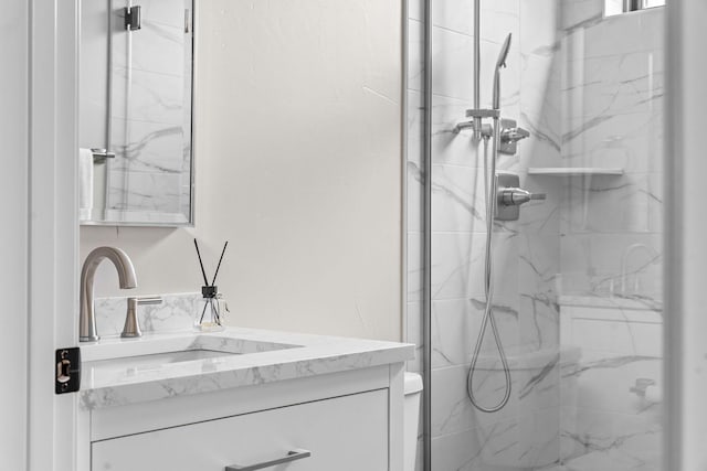 full bathroom featuring vanity and a marble finish shower