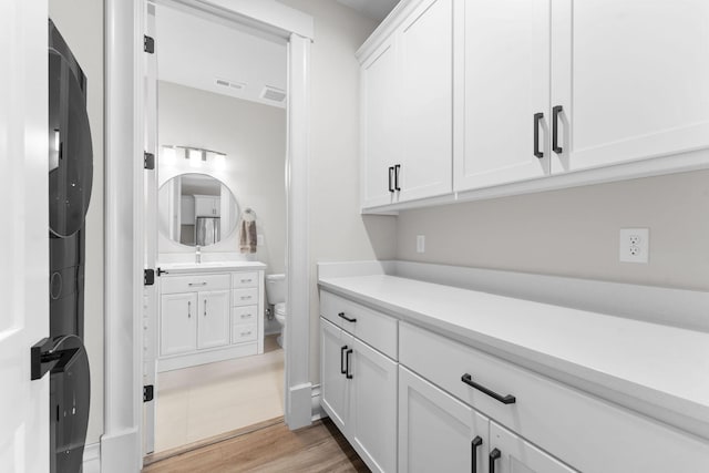 bathroom with visible vents, wood finished floors, toilet, and vanity