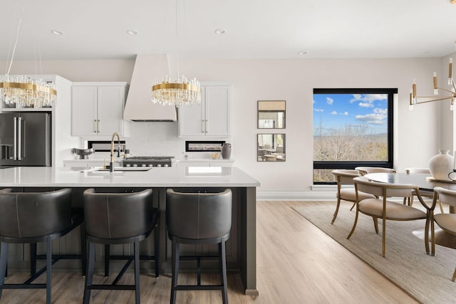 kitchen with premium range hood, light countertops, high end fridge, and tasteful backsplash