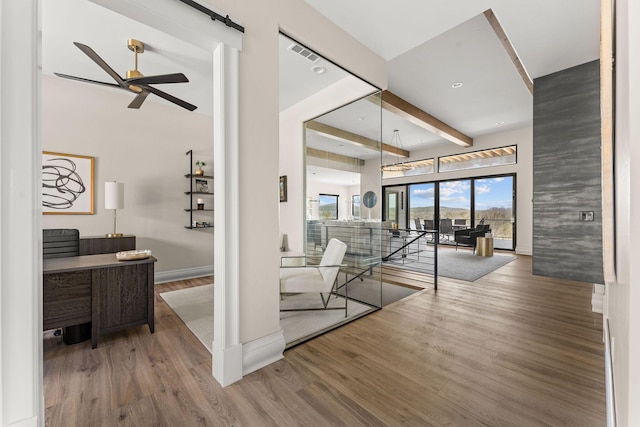 interior space with visible vents, baseboards, beamed ceiling, and wood finished floors