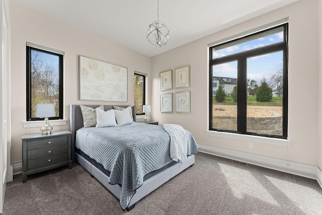 bedroom featuring an inviting chandelier, baseboards, dark carpet, and visible vents